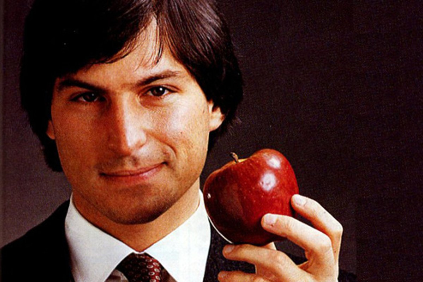 Один из основателей Apple Стив Джобс держит яблоко